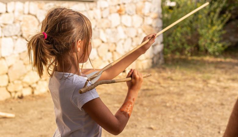 Jeune fille tir au propulseur préhistorique